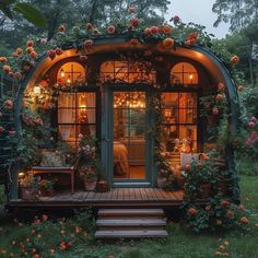 a small house with lots of flowers on the outside