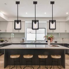 a kitchen with an island and three stools in front of the countertop area