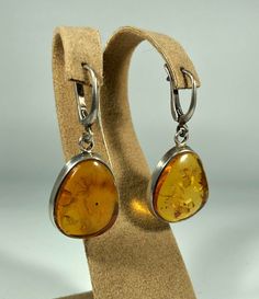 Valentines Day Perfect Gift!Elevate your style with our Handmade Earrings featuring spectacular orange amber set in textured 925 sterling silver. These exquisite earrings are designed for women who appreciate unique and original jewelry. The vibrant orange amber stones are beautifully complemented by the textured silver, creating a stunning and eye-catching piece that adds a touch of elegance and sophistication to any outfit. Product Details: Material: 925 Sterling Silver Stone: Orange Design: T Formal Amber Citrine Earrings, Handmade Amber Earrings For Anniversary, Silver Baltic Amber Earrings, Amber Dangle Earrings For Anniversary, Classic Amber Earrings For Gift, Classic Amber Sterling Silver Earrings, Amber Dangle Earrings For Formal Occasions, Orange Teardrop Sterling Silver Earrings, Amber Citrine Teardrop Earrings