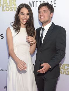 a man and woman standing next to each other on a red carpet