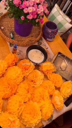 flowers and candles on a table in front of a wicker basket