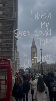 people walking down the street in front of a red phone booth with words written on it