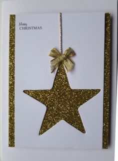 a christmas card with a gold star hanging from it's side