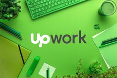 the word upwork is surrounded by various office supplies and green plants on a desk