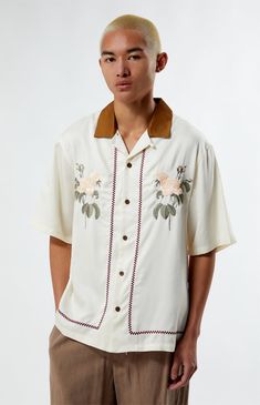 Embrace vintage charm with the Eli Oversized Camp Shirt from PacSun. This shirt features a classic collared neckline, short sleeves, and an oversized fit for a laid-back look. With button closures, floral embroidery and a timeless design, it's perfect for adding retro flair to your wardrobe. 


	Contrast collar
	Short sleeves
	Relaxed fit
	Floral embroidery
	Button closures
	100% Tencel
	Machine washable
	Model is wearing size medium
	Model Measurements: 6'0” Height, 36L Suit, 30” Waist, 32” Inseam Beige Camp Shirt With Relaxed Fit And Camp Collar, Beige Johnny Collar Shirt With Relaxed Fit, Casual Cream Top With Camp Collar, Summer Cream Camp Shirt With Relaxed Fit, Casual Cream Collared Camp Shirt, Beige Johnny Collar Shirt For Summer, Cream Camp Collar Shirt For Summer, Cream Summer Shirt With Camp Collar, Summer Cream Shirt With Camp Collar