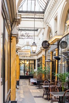 the inside of a building with tables, chairs and plants on display in front of it