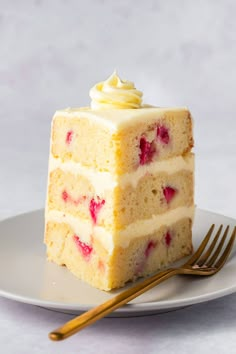 there is a piece of cake on the plate with strawberries and cream frosting