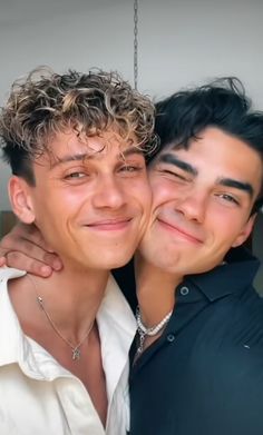 two young men are hugging each other and smiling