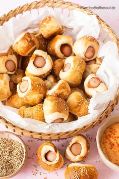 a basket filled with pigs in a blanket next to other foods