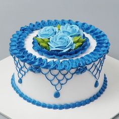 a white cake with blue icing and flowers on top