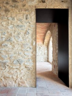 an open door in a stone building with brick flooring and walls that have been made out of bricks