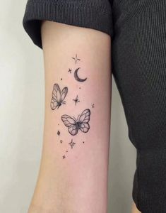 a woman's arm with butterflies and stars on it