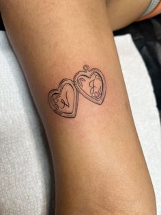 two heart shaped tattoos on the arm