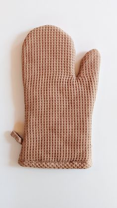 a brown oven mitt sitting on top of a white wall