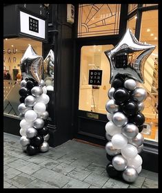 two black and white balloons in front of a store