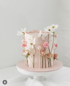 a pink cake with white flowers on top