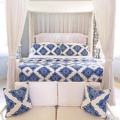 a bed with blue and white bedspread in a bedroom