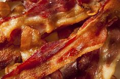 bacon strips are piled on top of each other in this close up photo, with red and yellow colors