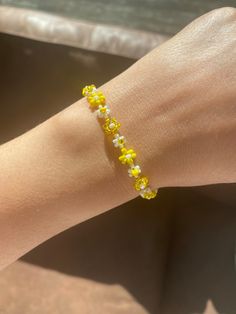 Yellow bead bracelet with a delicate design. The Floral Daisy Bracelet will brighten up your look. A beaded bracelet crafted by hand with high-quality beads.  Thank you very much for visiting our shop. We hope you have a great shopping experience! If you are struggling to find the information you need, please feel free to contact us. Do not forget to take a look at our other products in our shop. 😊 Yellow And White Beaded Bracelets, Cheap Elegant Yellow Beaded Bracelets, Yellow Bead Bracelet Ideas, Trendy Beaded Flower Bracelets, Trendy Yellow Beaded Bracelets With Tiny Beads, Trendy Flower-shaped Beaded Bracelets, Trendy Yellow Beaded Bracelets, Spring Beaded Bracelets With Flower Shape And Tiny Beads, Spring Beaded Bracelets With Tiny Flower Beads