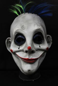 a creepy mask with green hair and blue eyes