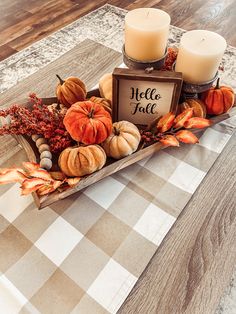 a centerpiece with candles and pumpkins on a table