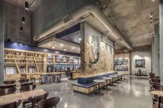 the interior of a library with tables, benches and bookshelves on either side