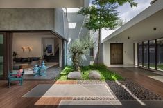 an outdoor living area with wooden floors and green plants