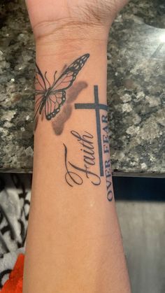 a woman's wrist with a butterfly on it and the word faith written in cursive writing