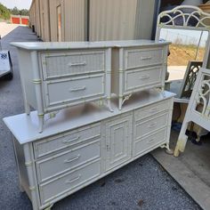 an old dresser is painted white with gold trim