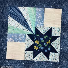 a blue and white patchwork quilt with a black star on the center, surrounded by small stars