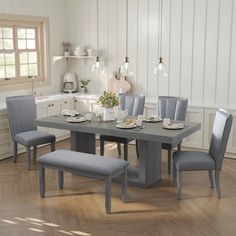 a dining room table with chairs and a bench in front of the table is shown