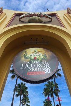 an entrance to the hollywood horror nights with palm trees and blue sky in the background