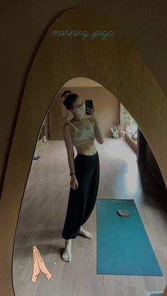 a woman standing in front of a mirror taking a selfie