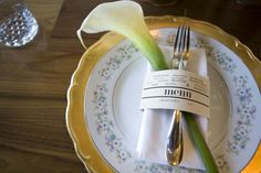 a plate with a fork, knife and napkin on it that is decorated with flowers