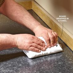 a man is wiping his hands with a cloth on the counter top, while he uses a sharp knife to clean it