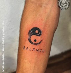 a black and white tattoo with the word balance on it's left arm, next to a yin symbol