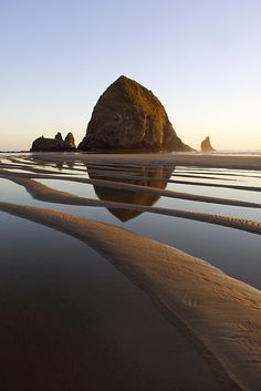 the reflection of two rocks in the water at low tide beach, olympic national park