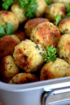 a metal container filled with meatballs covered in parsley