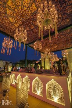 the interior of a restaurant with chandeliers hanging from the ceiling and lights on the walls