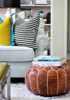 a living room filled with furniture and lots of pillows on top of a white rug