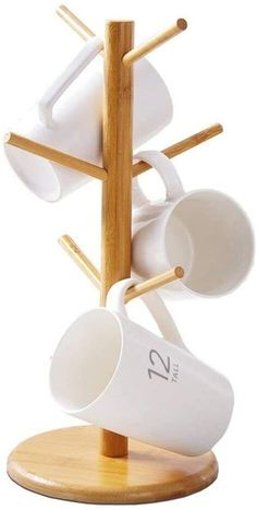 there is a cup and saucer holder on the wooden stand with two mugs in it