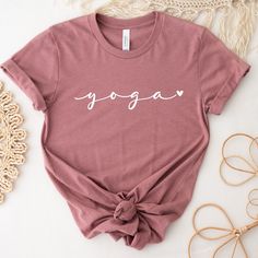 Cute Yoga Shirt! This shirt is the perfect tee for yoga classes and for everyday wearing. Beautiful gift for a friend or for treat yourself, this shirt has a  cute and minimalist design, with a powerful practice: YOGA ❤ * DETAILS: T-shirts: Bella + Canvas - super soft and high quality shirts Material: Cotton/Poly Blend Design: is applied using high quality heat transfer vinyl and is applied to each shirt with a commercial grade heat press. Model: Unisex Sleeves: they are rolled up for display purposes only Printed in the USA *SIZING For sizing, please refer to the size chart in the pictures or contact us. Our t-shirts are unisex. Women should order one (1) size down if they prefer a slimmer fit. Size chart is included in images. *COLORS Color chart is available in images with all colors av Pink Athleisure T-shirt For Yoga, Sporty Yoga T-shirt With Letter Print, Relaxed Fit Yoga T-shirt With Letter Print, Cotton Relaxed Fit Top For Meditation, Casual Short Sleeve Tops For Pilates, Crew Neck Stretch T-shirt For Pilates, Pink Short Sleeve Yoga Top, Pink Short Sleeve Tops For Yoga, Pink Sporty T-shirt For Yoga