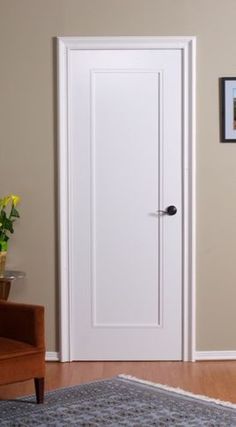 a living room with a brown chair and a white door in the middle of it