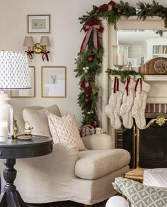 a living room decorated for christmas with stockings on the fireplace