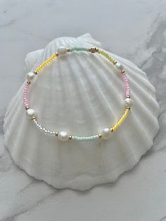 ♡ Bloom ♡ Bracelet Our Gorgeous Bloom bracelet is made with beautiful Pastel coloured beads and Freshwater Pearls. The perfect addition to your Bracelet stack! Please bear in mind that all Freshwater Pearls have unique shapes and sizes, no two pearls look the same. ♥ small Pale yellow, pale pink, light orange, mint & Ivory Gold cluster beads ♥ small Freshwater Pearl (approx 0.6 cm) ♥ Gold plated spacer beads ♥ Stretchy cord ↠ All my jewellery is handmade by me in the U.K ↠ I will ship next day where possible except for weekends and on public holidays. ➸Care Instructions In order to keep your jewellery in perfect condition, we always advise keeping items out of contact with any chemicals, perfumes, lotions or water. Please be very careful when putting on or taking off  your jewellery. If yo Handmade White Pearl Bracelet For The Beach, Handmade Pastel Beaded Bracelets For Beach, Adjustable Pastel Beaded Bracelets For Beach, Adjustable Pastel Beaded Bracelet For Beach, White Pearl Bracelet With Colorful Beads For Beach, Colorful Beaded Strand Bracelets As Gift, Handmade White Stretch Strand Bracelet, Beach Jewelry With Pastel Beaded Details, Handmade Multicolor Pearl Bracelet For Beach