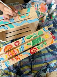 a child's hand is playing with wooden toys on a blanket and tablecloth