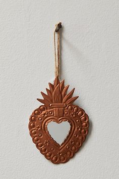 an ornament hanging on the wall with a heart shaped mirror in it's center