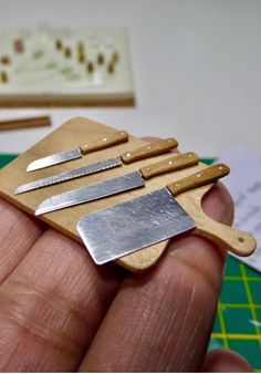 there is a small wooden cutting board with knives on it