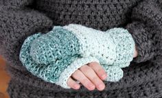 a close up of a person wearing a crocheted arm warmer with one hand on the wrist