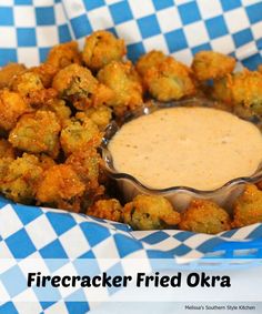 fried okra with dipping sauce in a blue basket on a checkered tablecloth